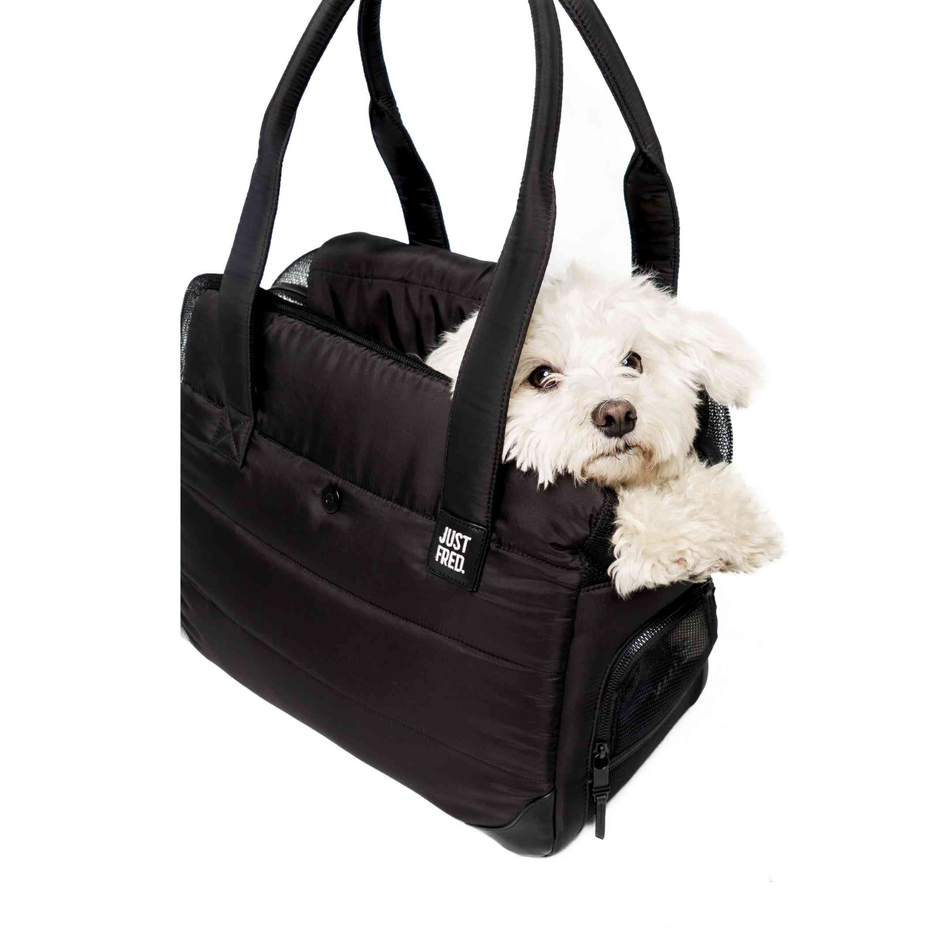 Black Just Fred Companion Tote pet carrier with a small white dog peeking out on a white background