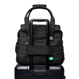 Black Just Fred Companion Dog Tote securely held on top of a suitcase on a white background